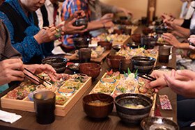 複数の人が囲んで和食を楽しんでいる様子